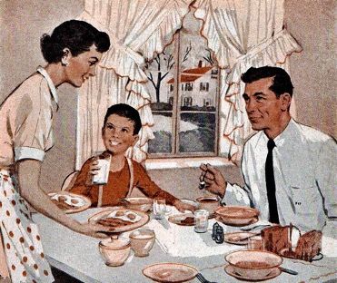 A family from the 1950s sits at their kitchen table with a classic American breakfast.