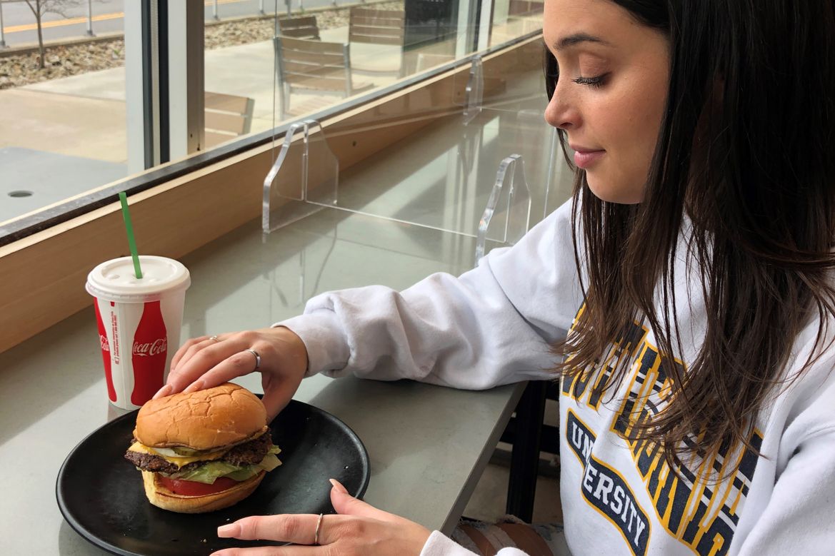 Student enjoying a vegetarian burger from Hugh Baby's at Evansdale Crossing